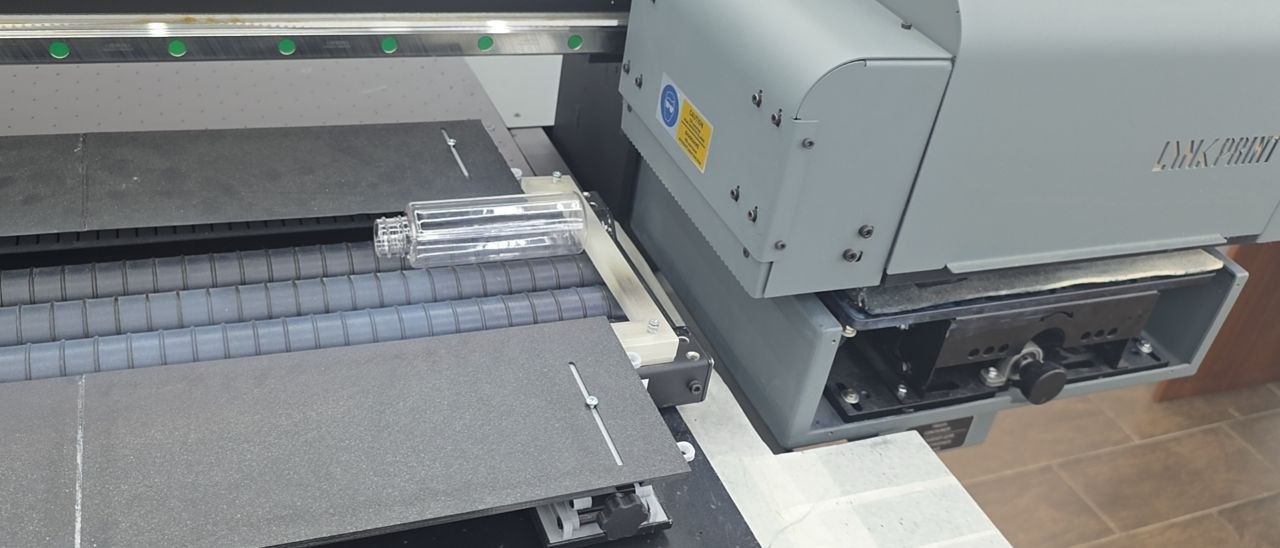 Печатная каретка LNK PRINT над прозрачной цилиндрической заготовкой